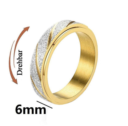 Ring in Silber/Gold mit geriffelter Fläche, welches als drehbar gekennzeichnet ist